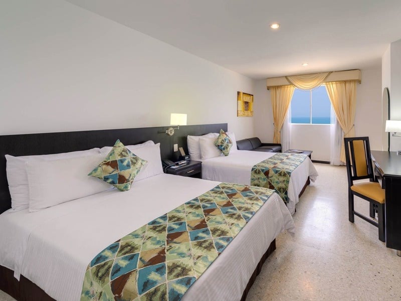 um quarto de hotel com duas camas e uma janela