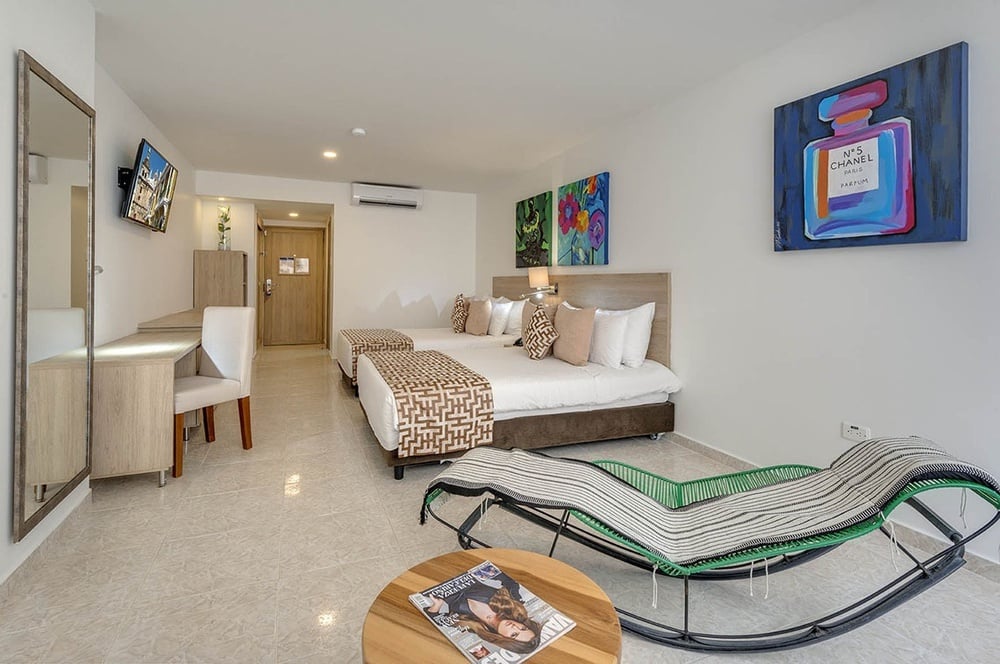 um quarto de hotel com duas camas e uma pintura de uma garrafa de perfume chanel