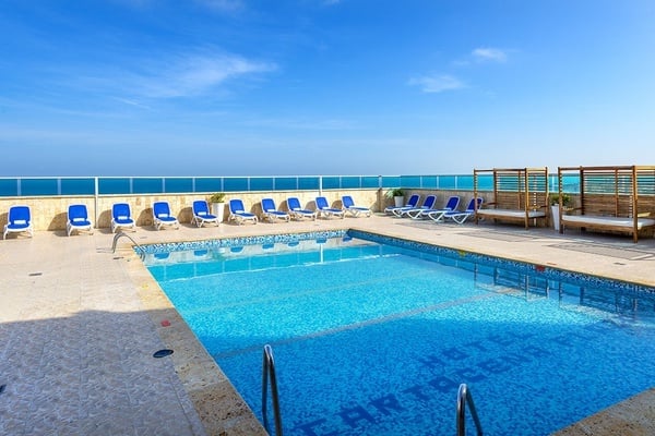 la piscina del hotel carolina está rodeada de sillas azules