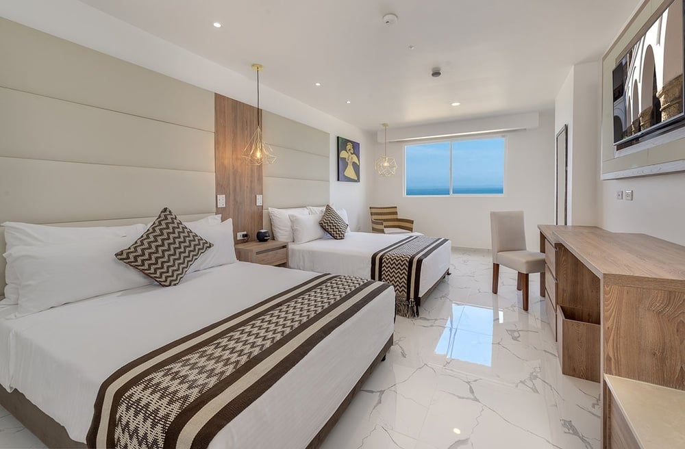 um quarto de hotel com duas camas e uma janela