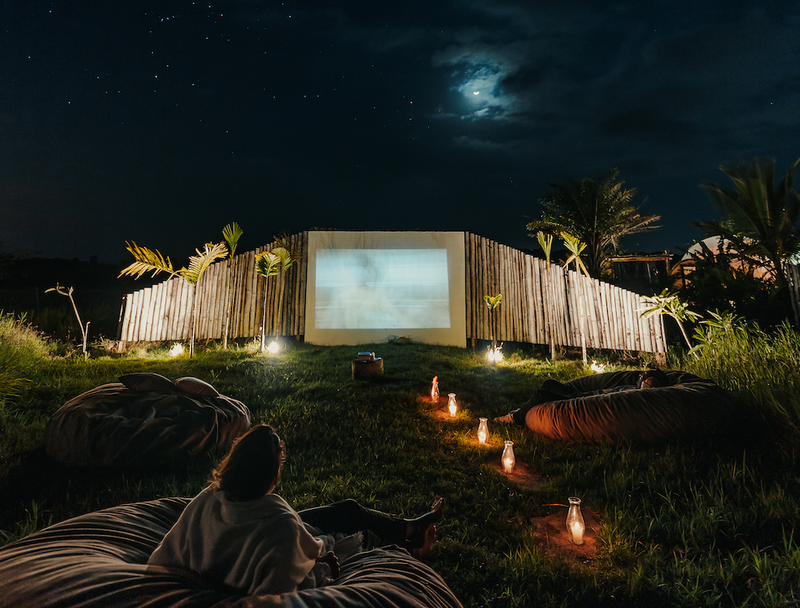 a woman sits on a bean bag chair watching a movie