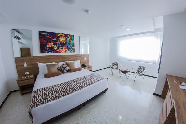 una habitación de hotel con una pintura de bob marley en la pared