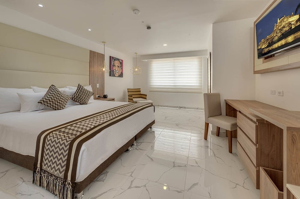 um quarto de hotel com uma cama king size e uma televisão