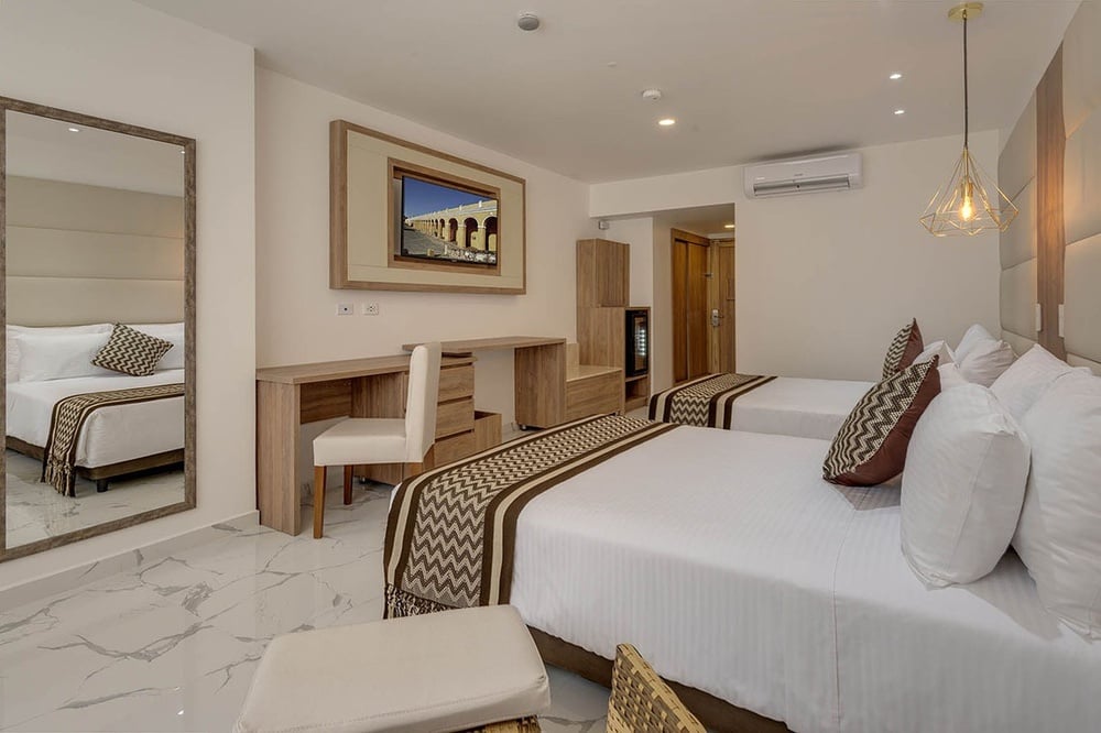 um quarto de hotel com duas camas e uma mesa