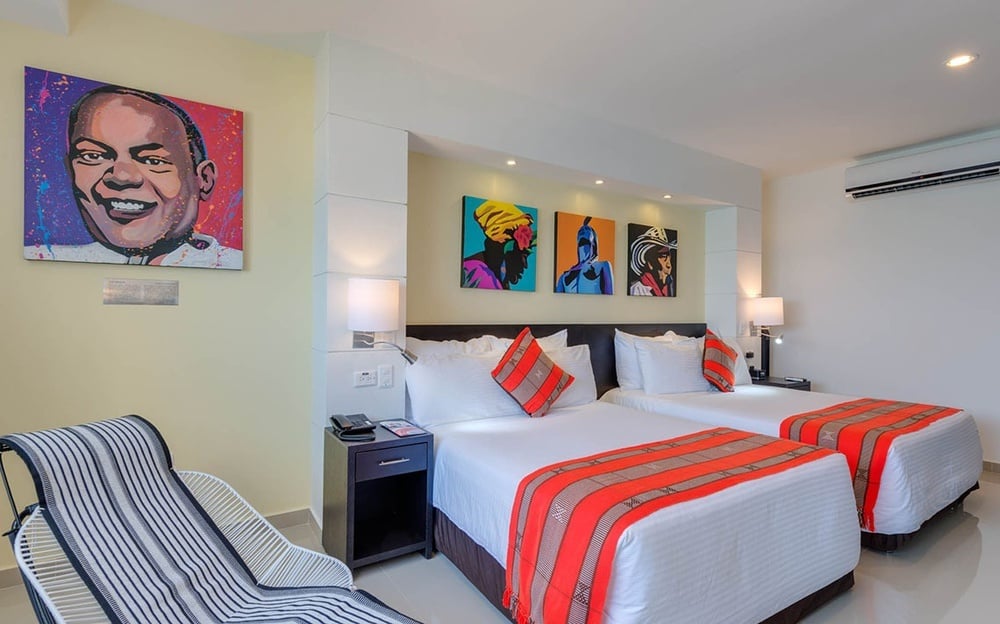 um quarto de hotel com duas camas e uma cadeira