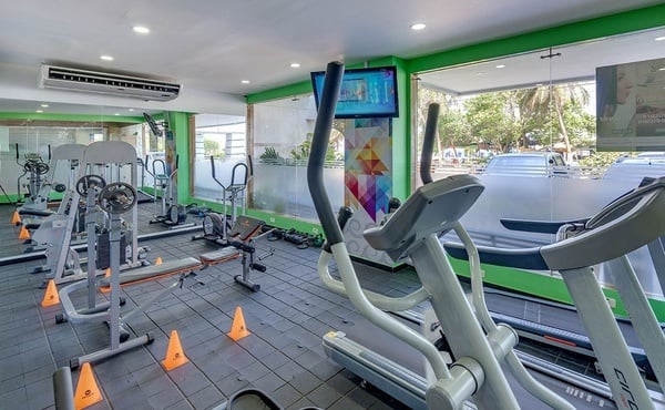 un gimnasio con muchos aparatos y una pantalla de televisión