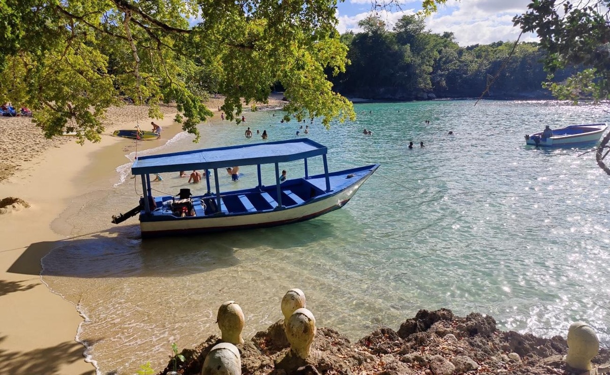un bote azul y blanco está en el agua en una playa