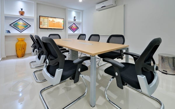 una sala de conferencias con una mesa y sillas