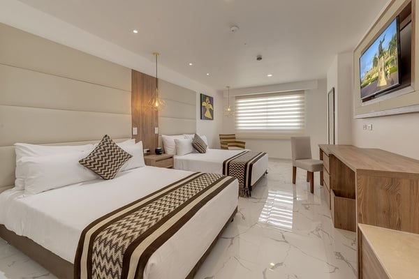una habitación de hotel con dos camas y una televisión