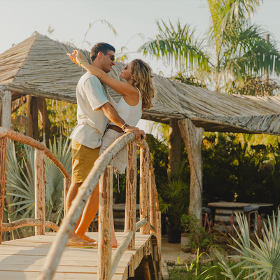 a man and woman are hugging on a wooden bridge