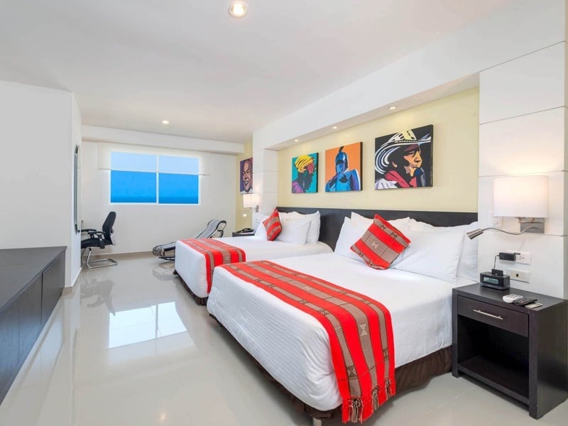 um quarto de hotel com duas camas e uma janela
