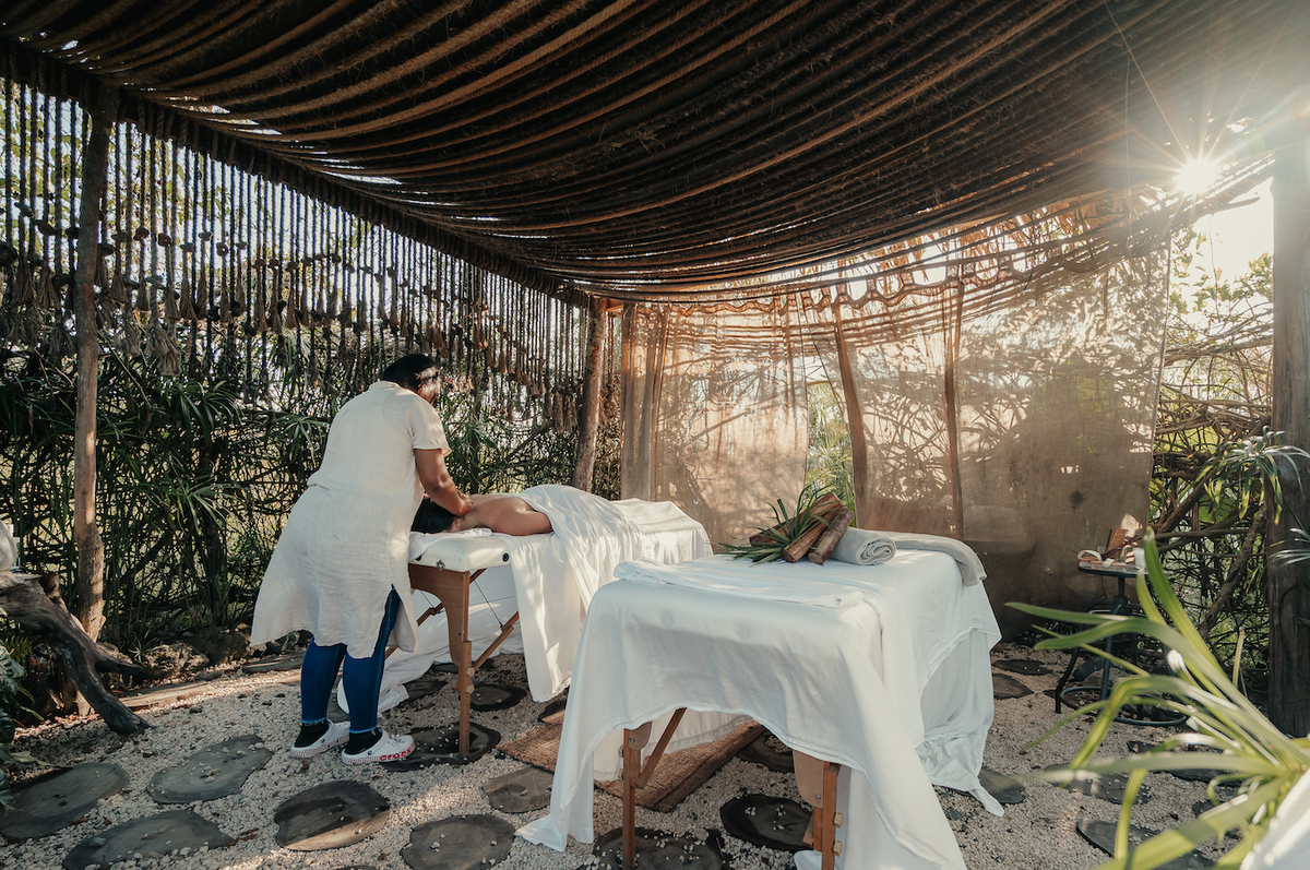 una mujer está dando un masaje a una persona en una mesa