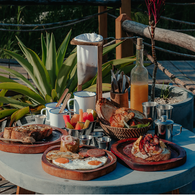 a table topped with plates of food and a bottle of orange juice
