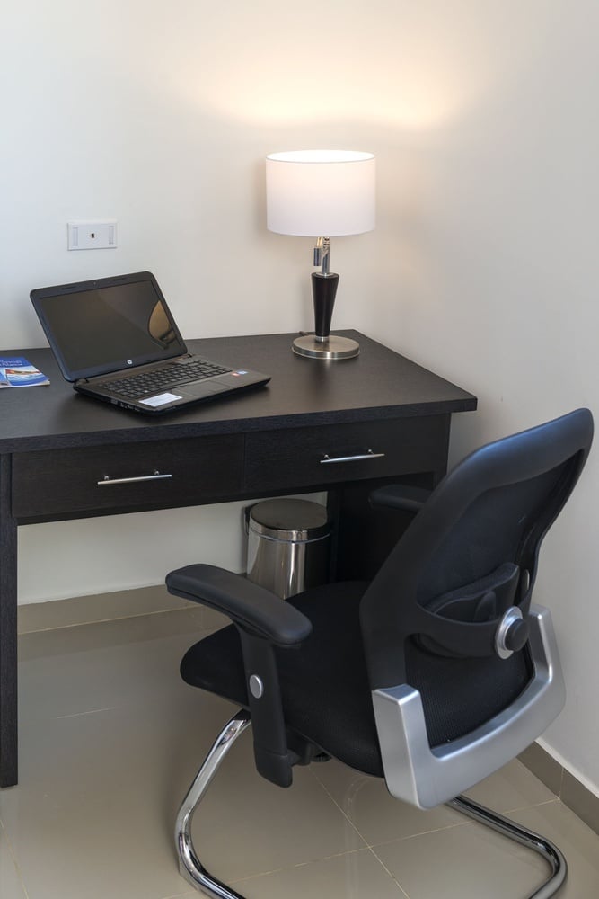 uma mesa com um laptop e uma cadeira