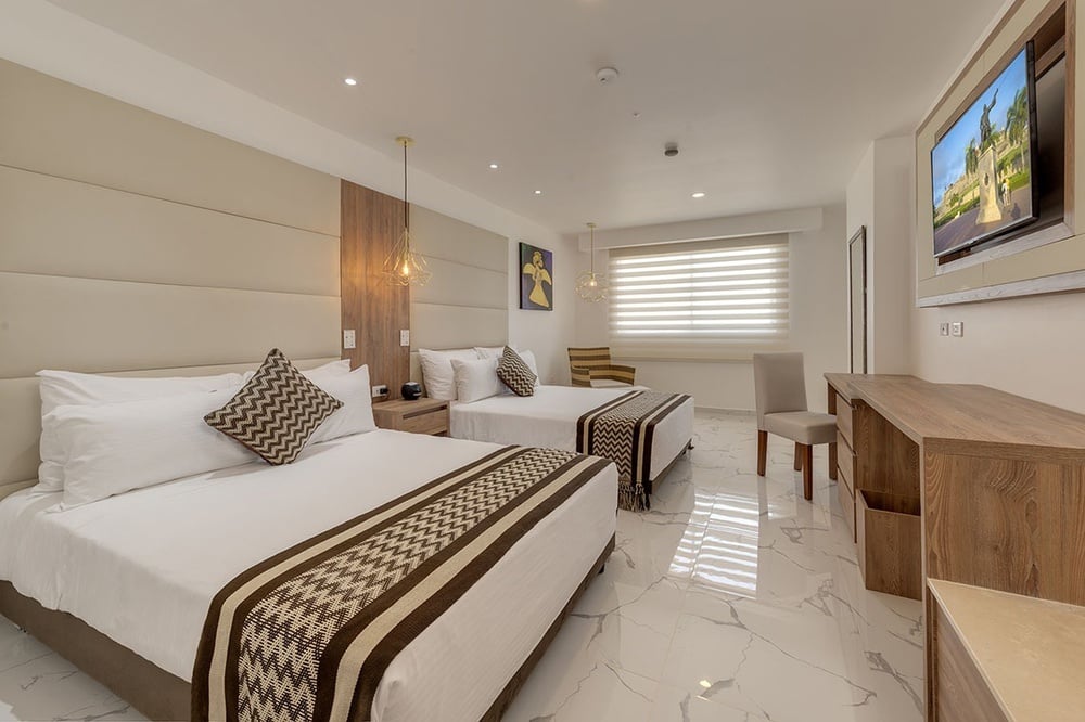 um quarto de hotel com duas camas e uma tv