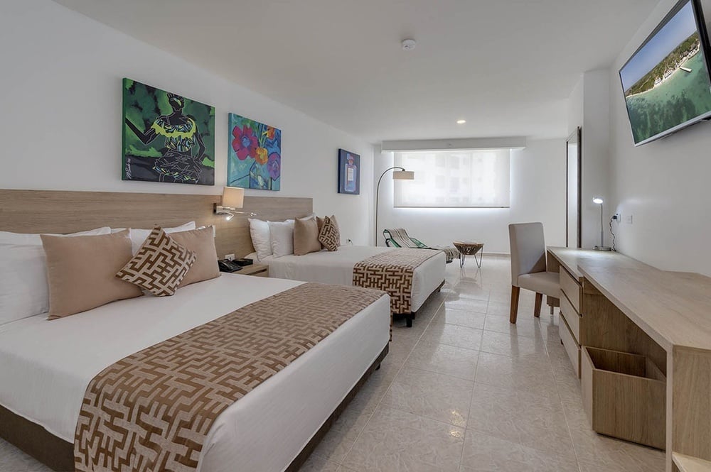 um quarto de hotel com duas camas e uma televisão