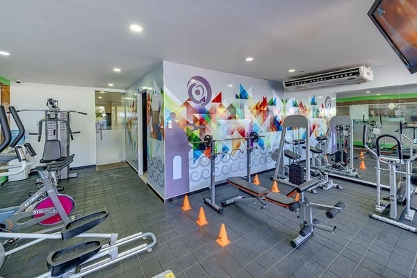 un gimnasio con muchos equipos y una pantalla de televisión