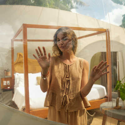 a woman is standing in front of a canopy bed