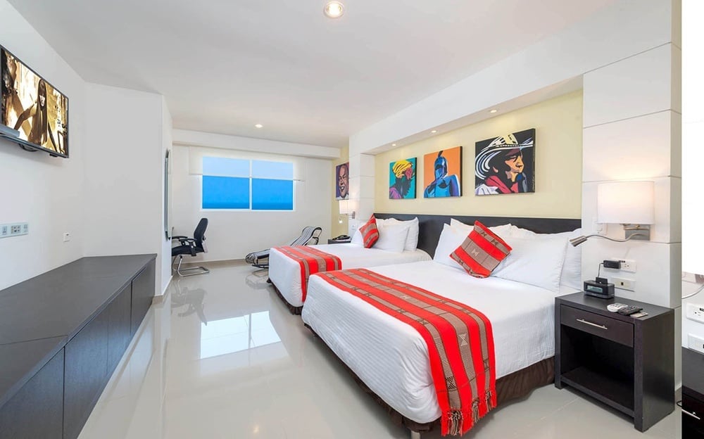 um quarto de hotel com duas camas e uma televisão
