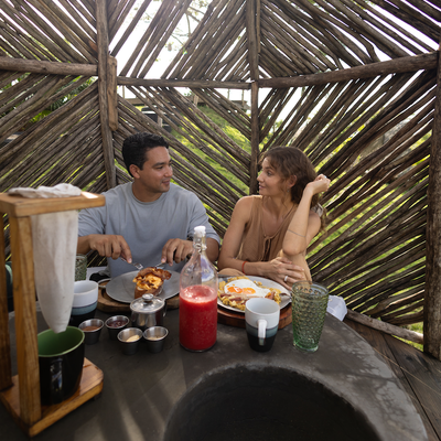 a man and a woman are sitting at a table eating food