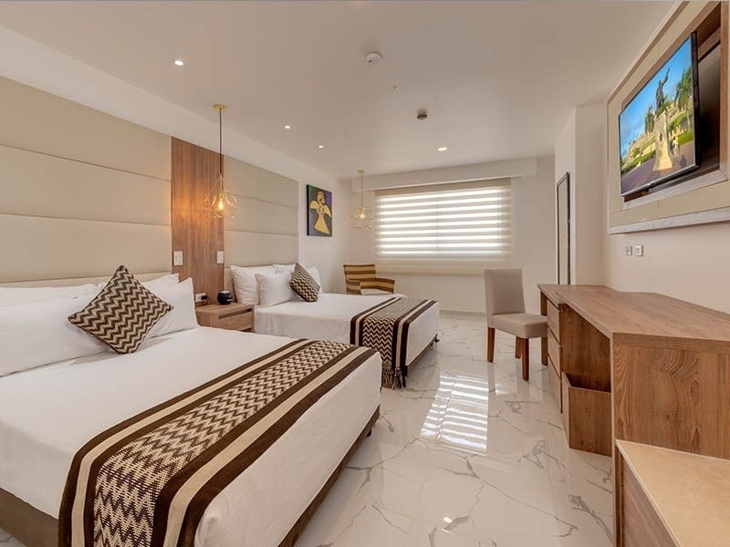 um quarto de hotel com duas camas e uma tv