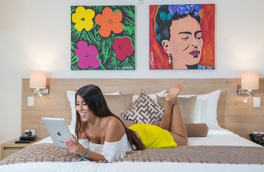 uma mulher está deitada em uma cama usando um tablet