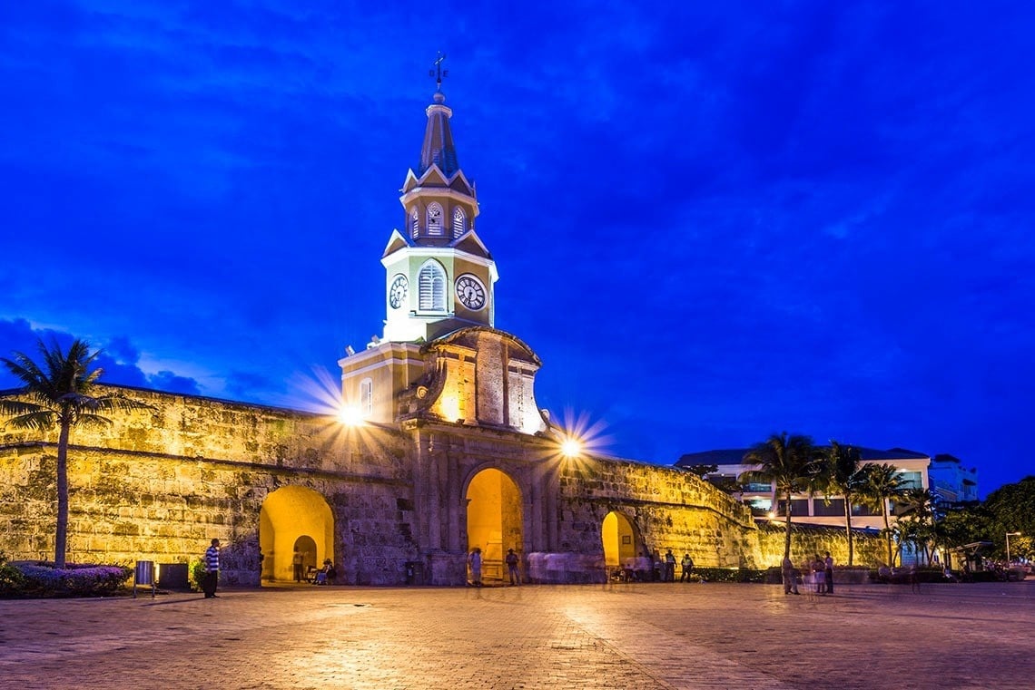 uma torre de relógio é iluminada ao entardecer