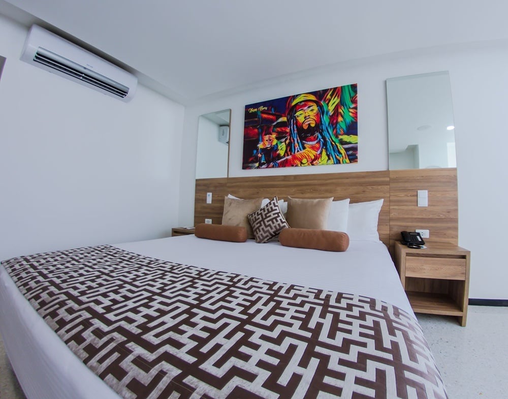 um quarto com uma cama e uma pintura de bob marley