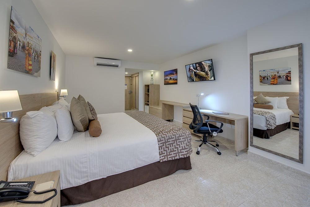 um quarto de hotel com uma cama king size e uma mesa