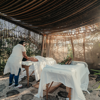 a woman is giving a man a massage under a canopy
