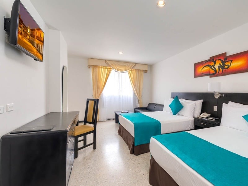 um quarto de hotel com duas camas e uma televisão