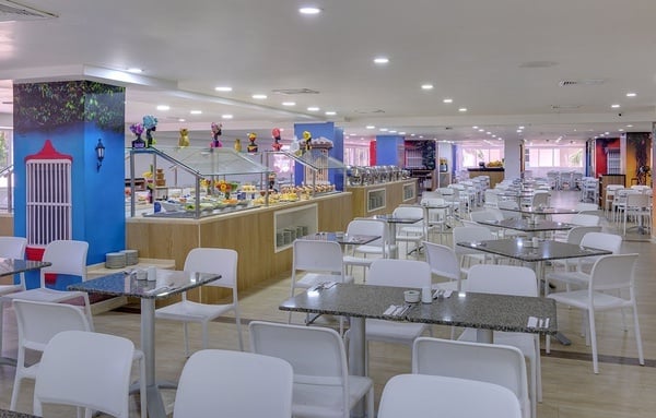 un restaurante con muchas mesas y sillas y un buffet