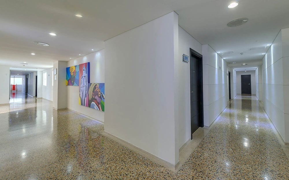 um corredor com paredes brancas e piso de mármore