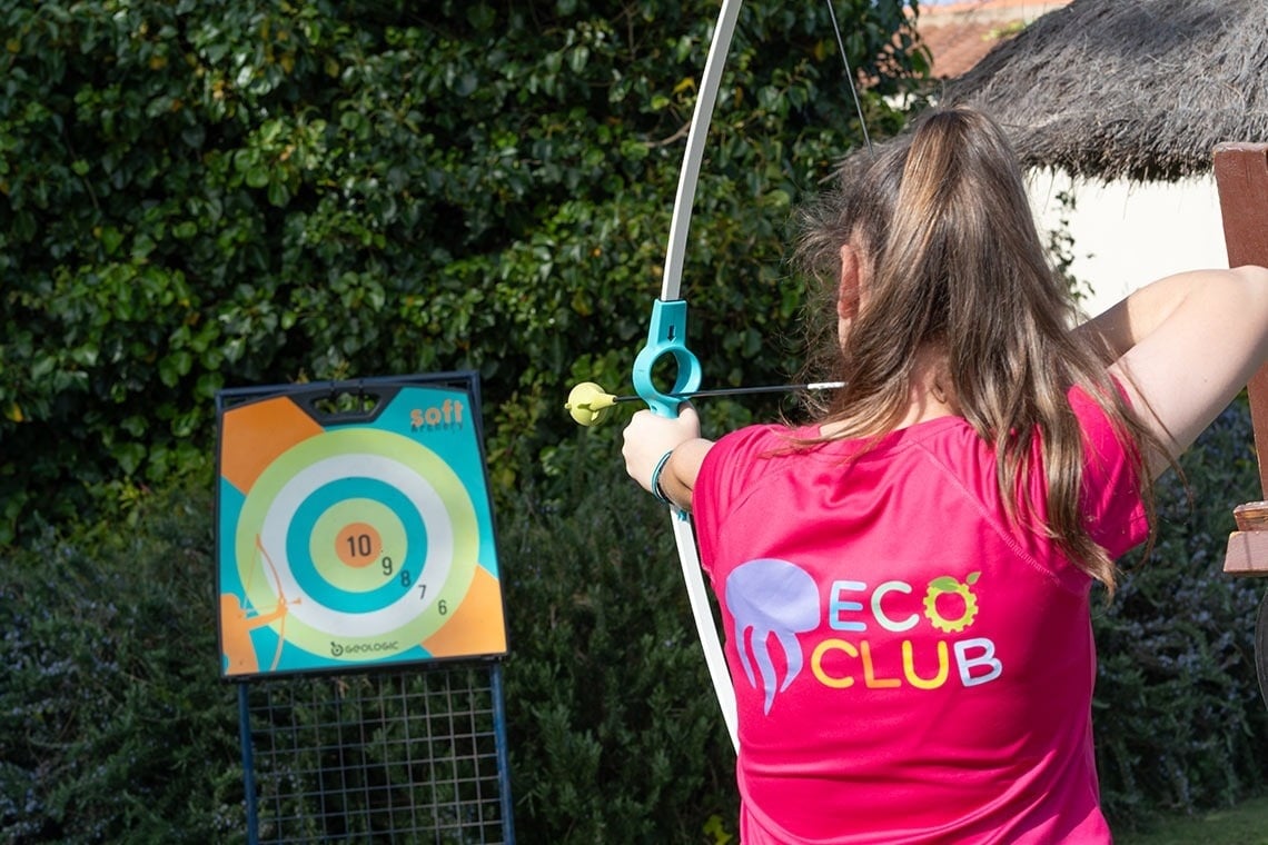 una estatua de un águila se sienta junto a una piscina con vistas al océano