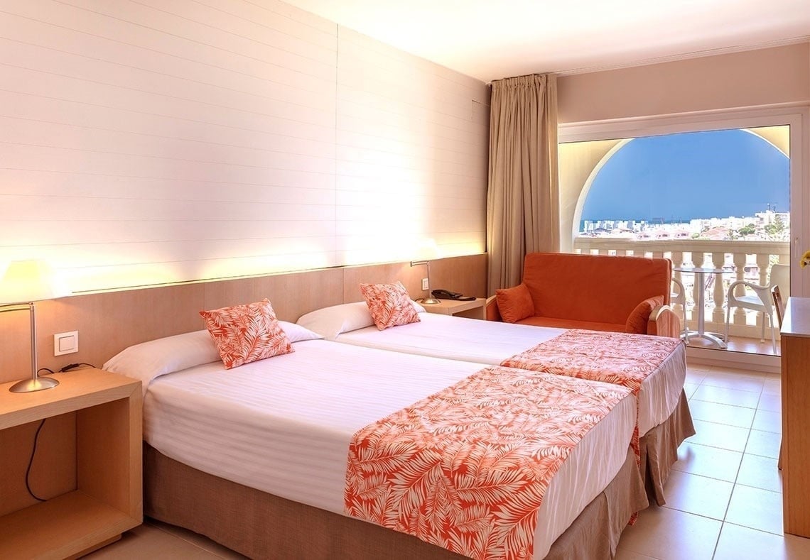 una habitación con dos camas y una silla