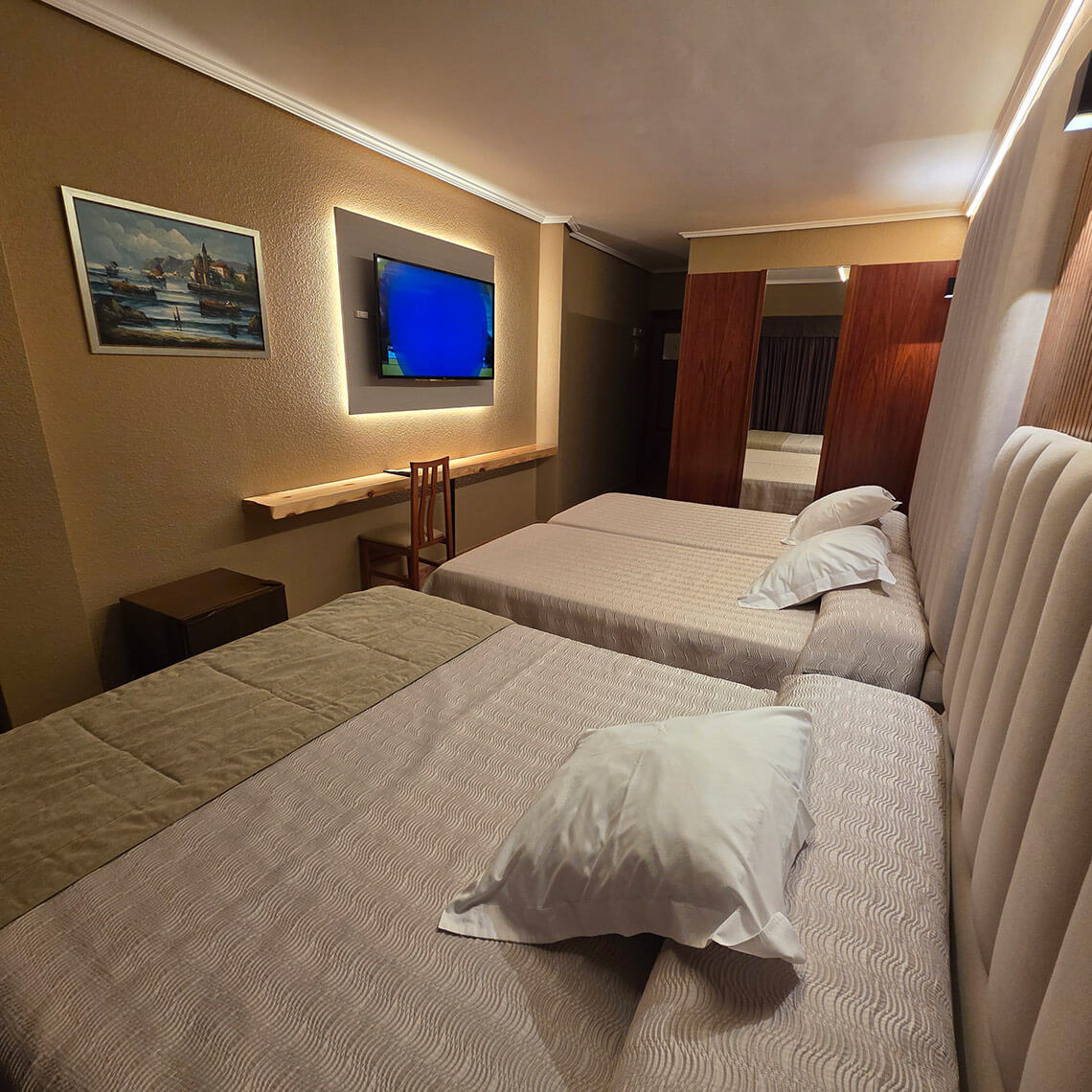 Comfortable hotel room with TEST 4 beds, TV, and modern decor.