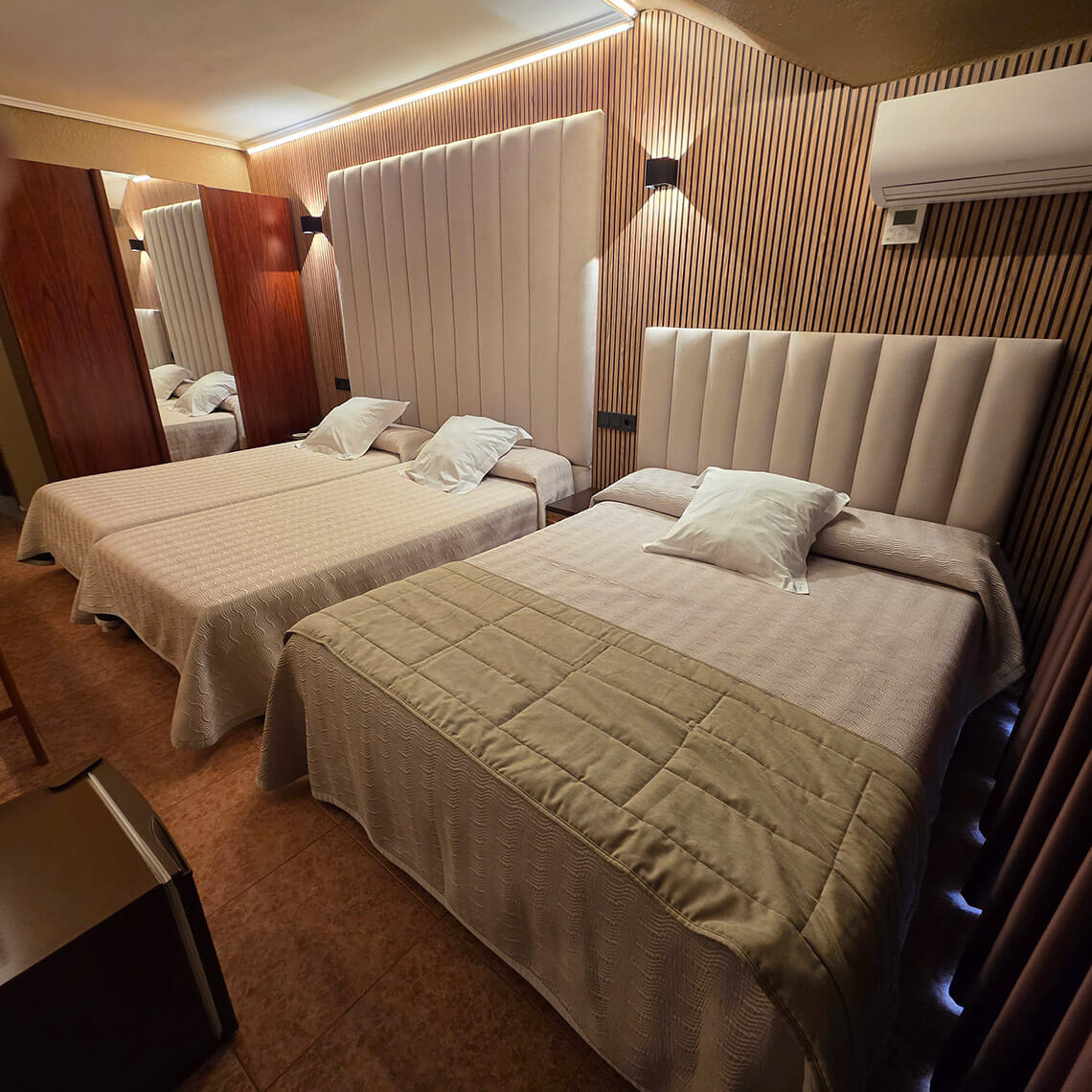 TEST 4: Two beds with tall padded headboards in a hotel room, one with a tan quilted throw.