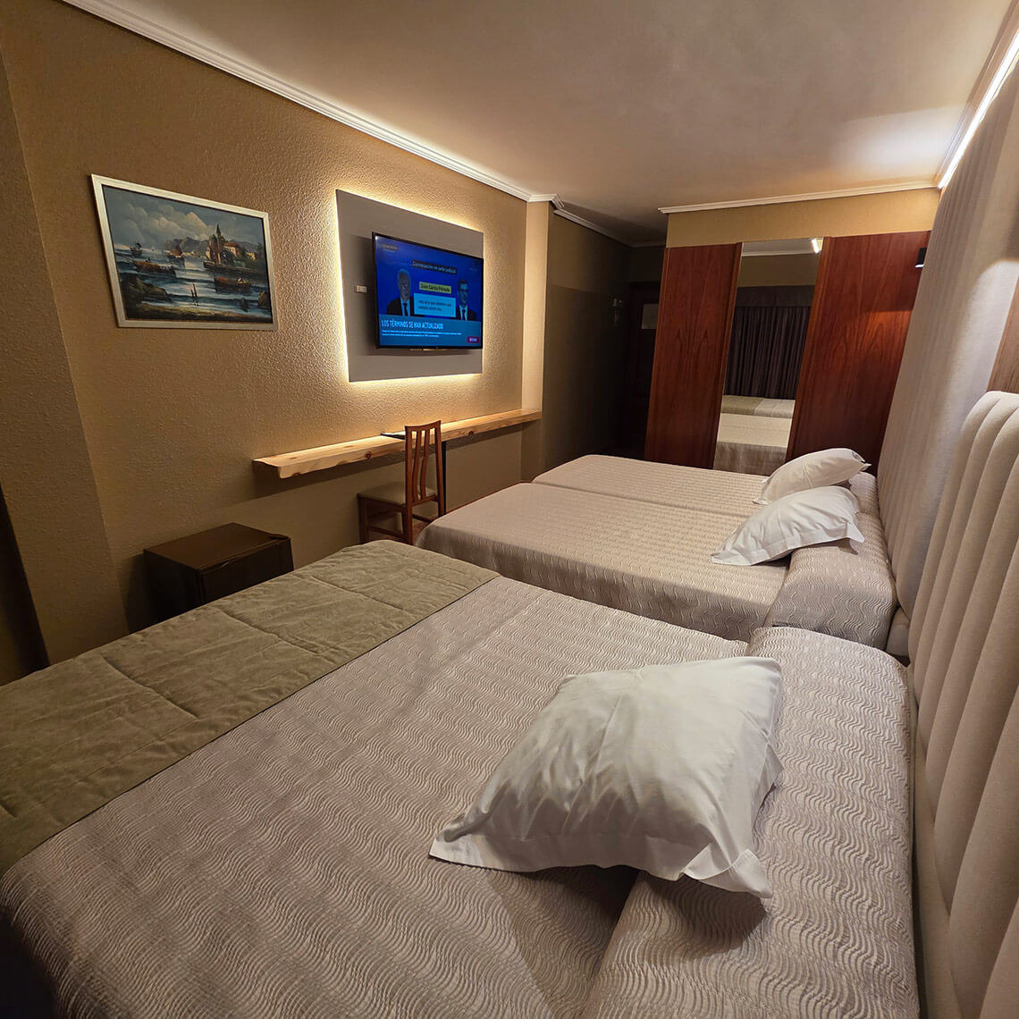 Hotel room TEST 4: Three beds, TV, and modern decor.