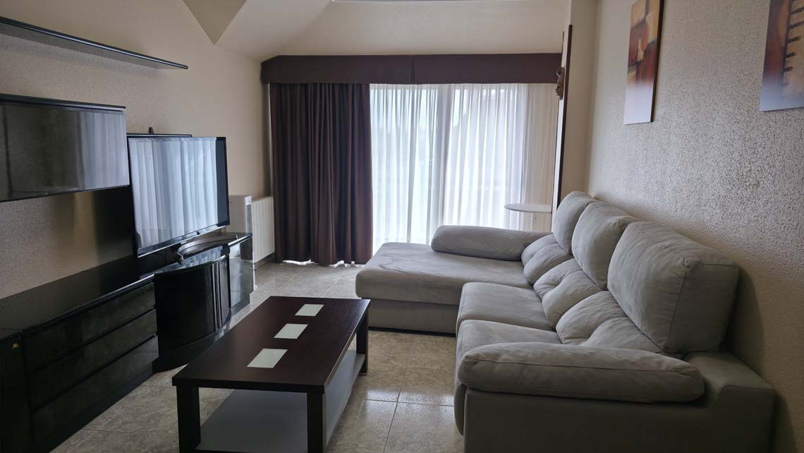 Spacious living room with a sectional sofa, TV, and coffee table, perfect for TEST 4.