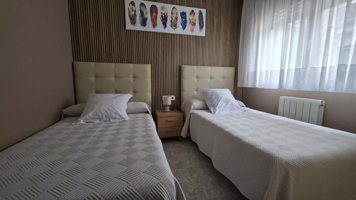 TEST 4: Twin beds with white bedding and quilted covers in a modern hotel room.