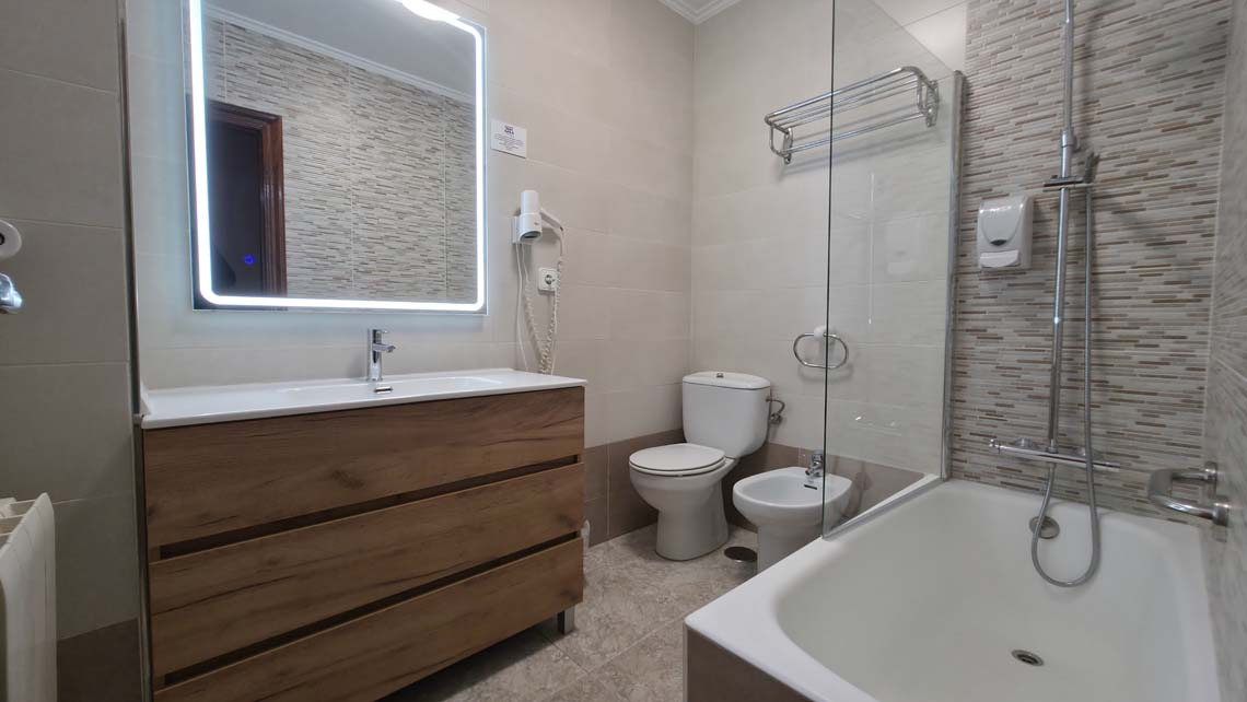 Modern bathroom with wooden vanity, bidet, and bathtub. Perfect for your TEST 4 stay.
