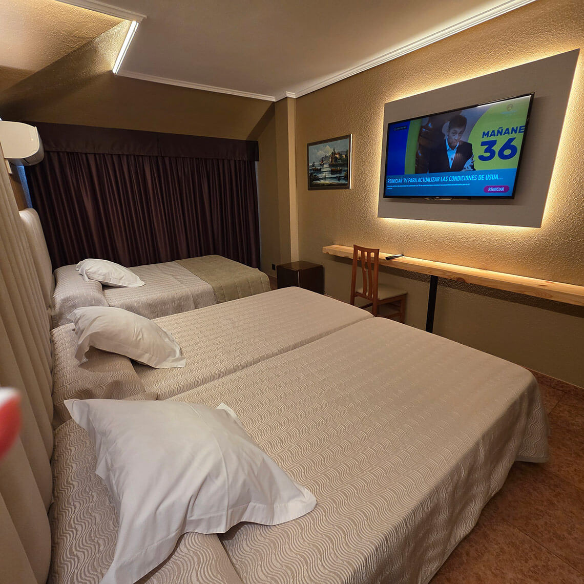 Twin beds, a desk, and TV in a hotel room, perfect for TEST 4 guests.
