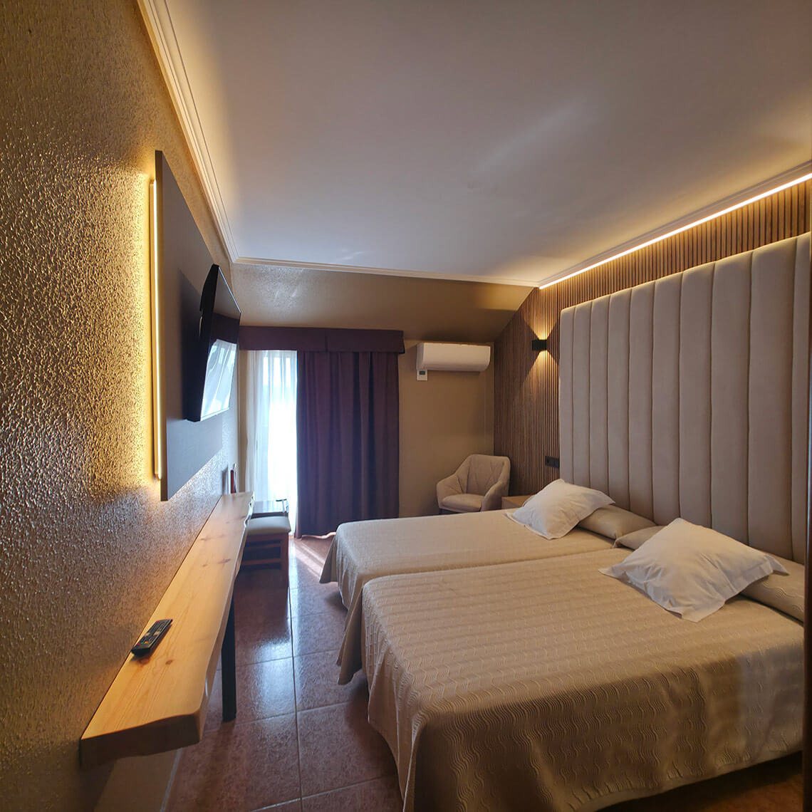 Modern hotel room with two beds, TV, and cozy armchair, ready for TEST 4.