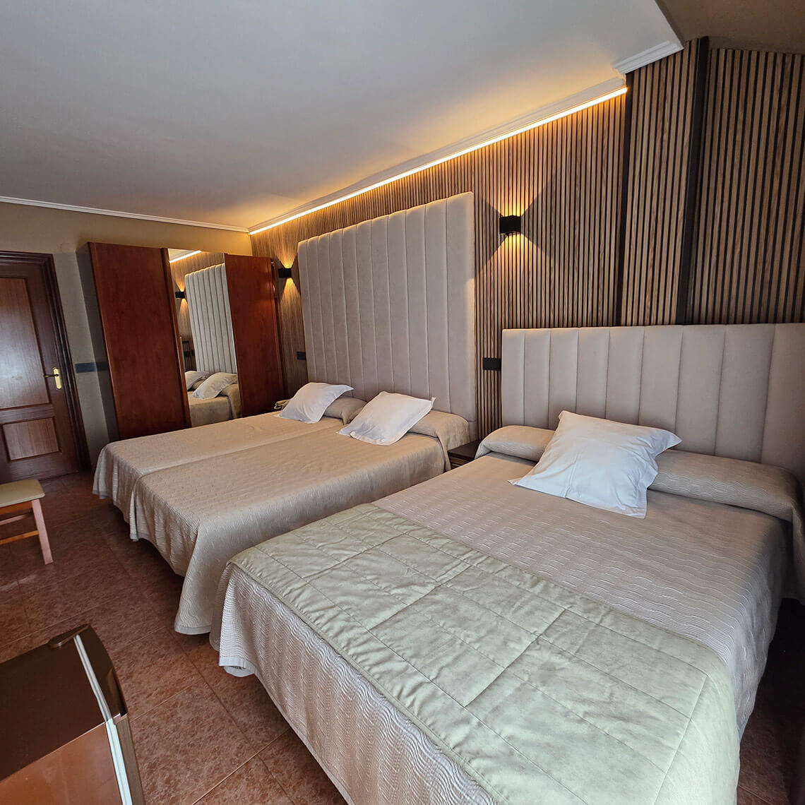 TEST 4 hotel room with two beds, plush headboards, and modern wood wall paneling.