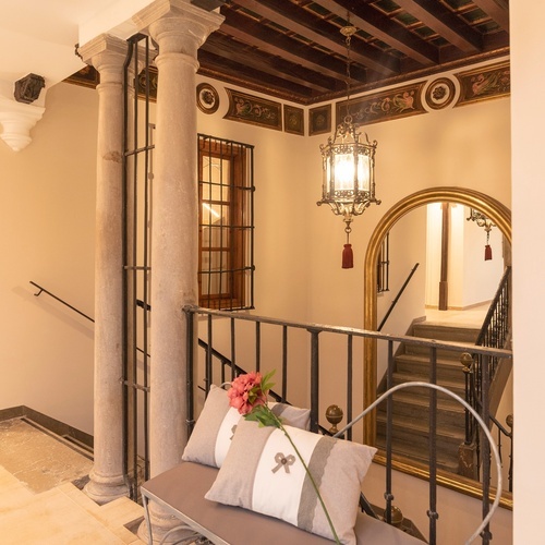 un banco con dos almohadas y una flor en él