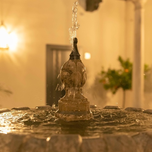 una vista aérea de un gran edificio blanco rodeado de palmeras y mesas y sillas