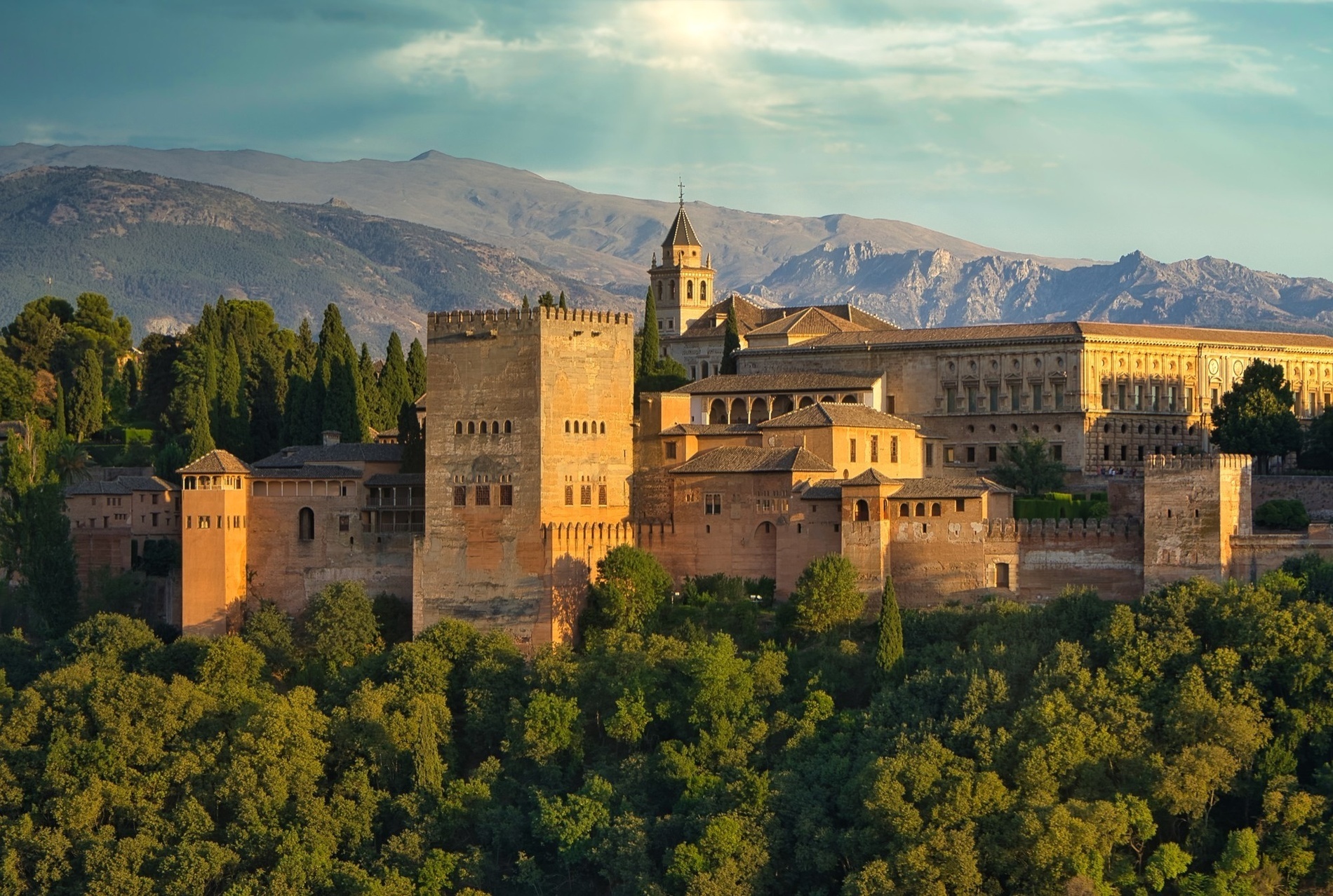 un camino de ladrillos conduce a un jardín con árboles y una estatua
