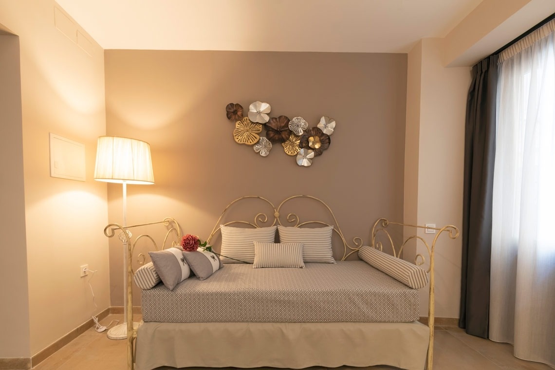 a bedroom with a bed and a lamp and a wall decoration