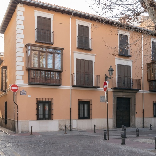 un edificio con balcones y una señal de tráfico en la esquina