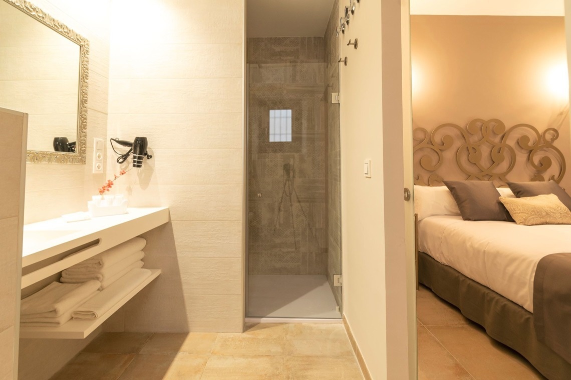 a bathroom with a walk in shower and a bed